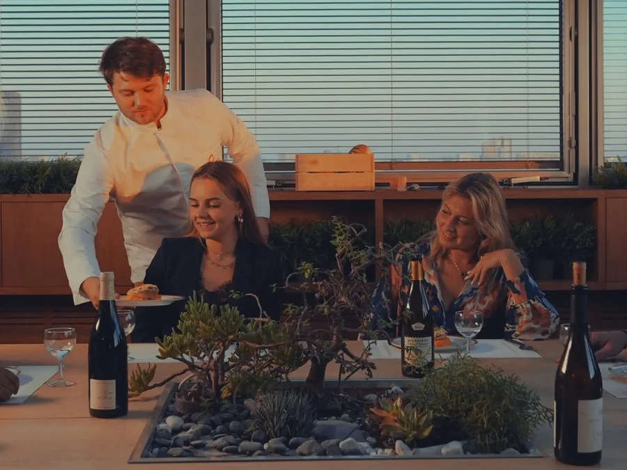 Chef à domicile servant deux convives à table, prestation pour conciergeries