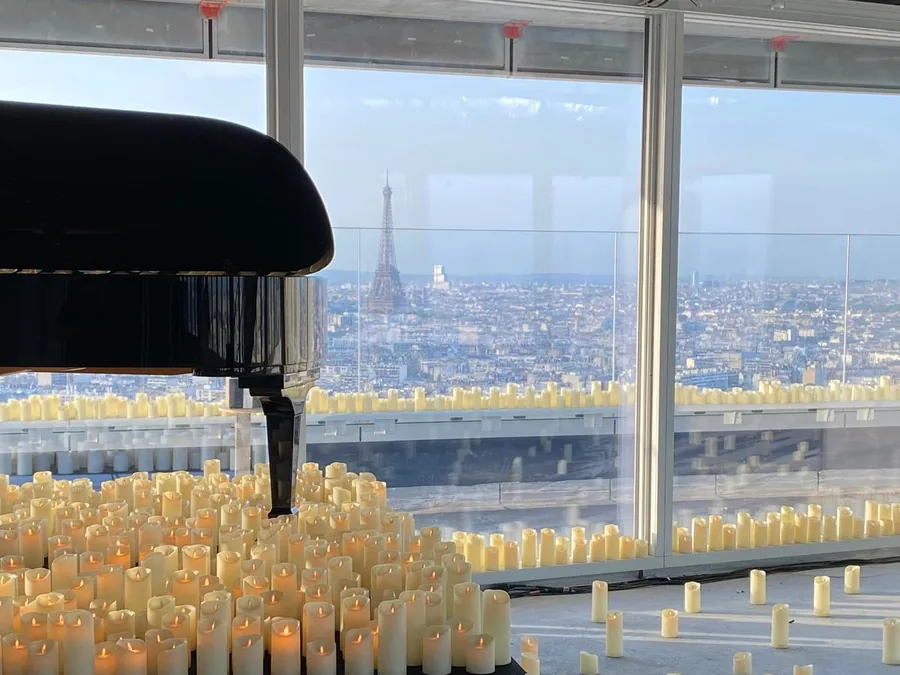 Piano à queue entouré de bougies devant la tour Eiffel, soirée organisée avec un chef à domicile
